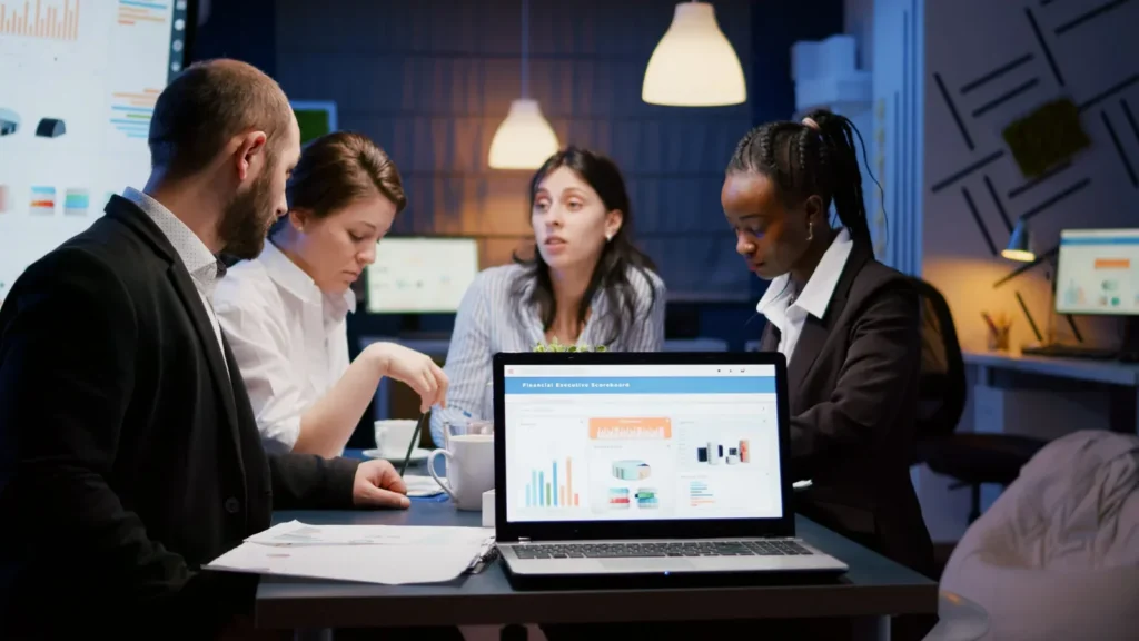 Business team reviewing performance dashboards on a laptop in a meeting room